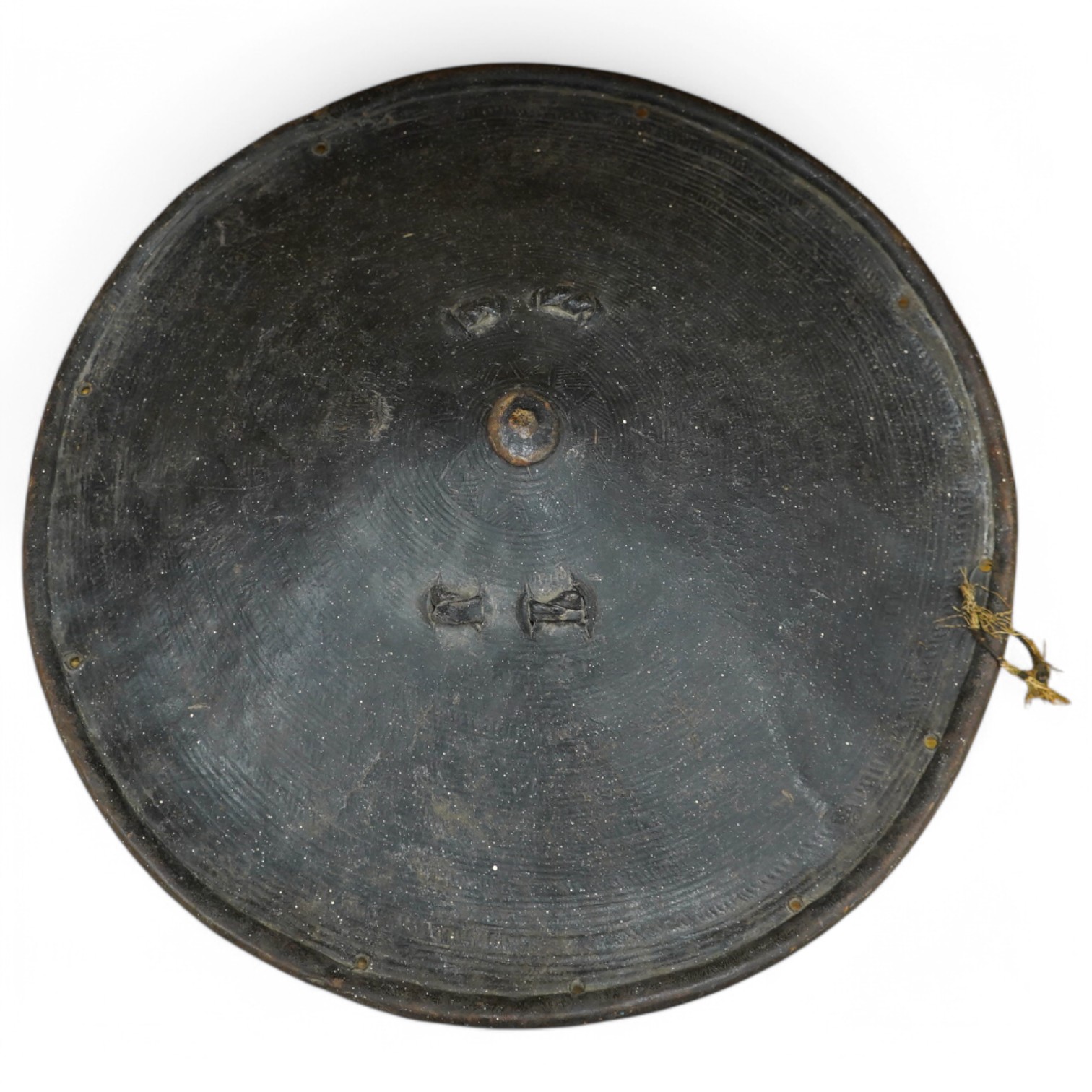 A 19th century Ethiopian/Somali leather shield, 56cm diameter, outside with incised geometric decoration rising to a point, reinforced brim, inside with woven leather handle. Condition - good.